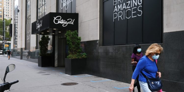 A shuttered Century 21 store with blacked out store windows.