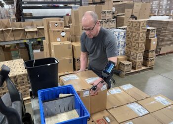 An Amazon worker lifting a heavy package.