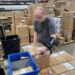 An Amazon worker lifting a heavy package.