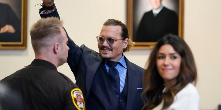 Actor Johnny Depp gestures to spectators in court after closing arguments at the Fairfax County Circuit Courthouse in Fairfax, Va., Friday, May 27,