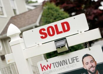 Sold sign in front of house.