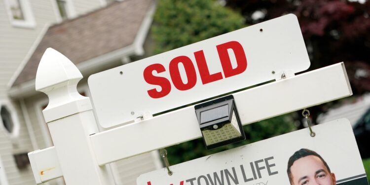 Sold sign in front of house.