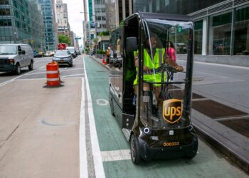 UPS worker Dyghton Anderson peddles an eQuad electric bike in a bicycle lane while delivering packages, in New York.