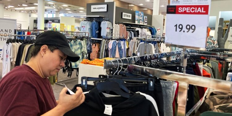 Customer checks price tags at clothing store.