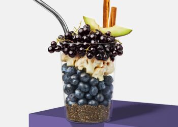 A cup with fruit and other ingredients for a smoothie.