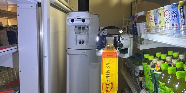 A restocking robot working in a grocery store aisle.