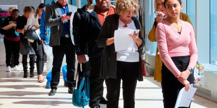 Applicants line up at a job fair.