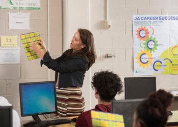 In this photo provided by Junior Achievement USA, volunteer Cammy Elquist LoRé teaches a Colorado Springs, Colo., high school class program.