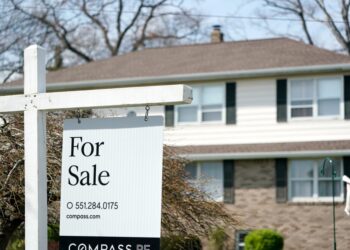 For sale sign in front of house.
