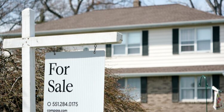 For sale sign in front of house.