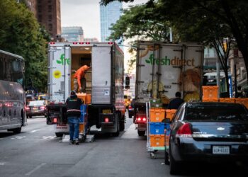 FreshDirect trucks block traffic on Columbus Avenue.