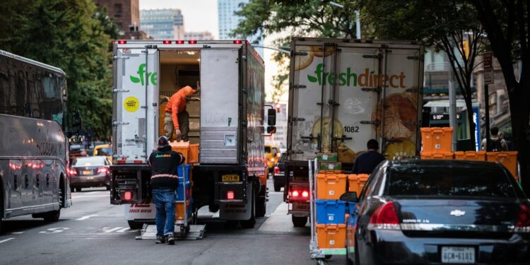 FreshDirect trucks block traffic on Columbus Avenue.