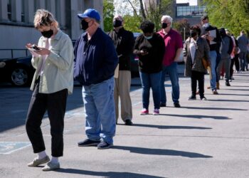 People line up outside a career center.