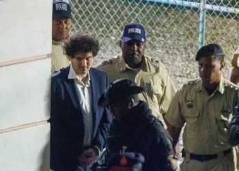 FTX founder Sam Bankman-Fried is seen in handcuffs as he leaves a court in the Bahamas