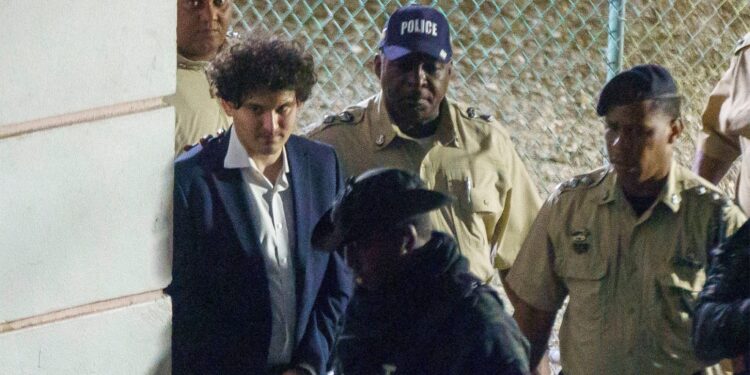FTX founder Sam Bankman-Fried is seen in handcuffs as he leaves a court in the Bahamas
