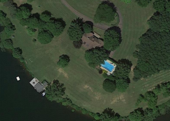 An aerial shot of the home which shows a pool as well as a boat dock.