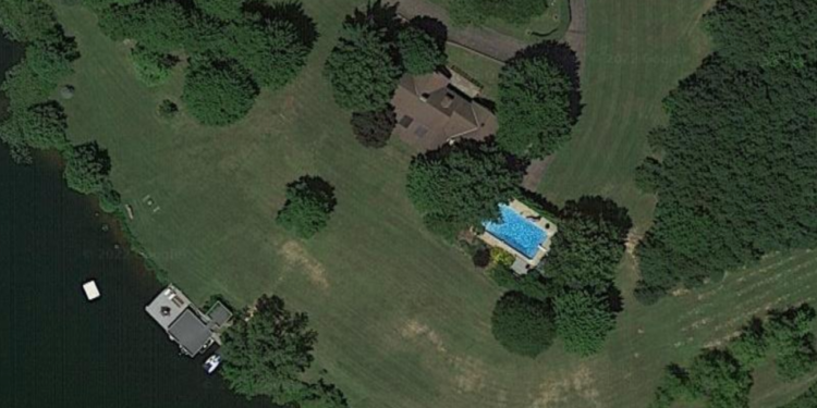 An aerial shot of the home which shows a pool as well as a boat dock.