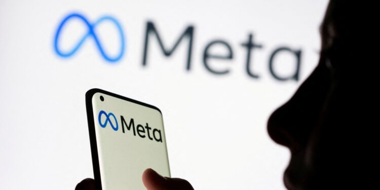 Woman holding smartphone with Meta's logo on it.