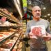 Moe Issa holding up a Rib Eye steak in his store.