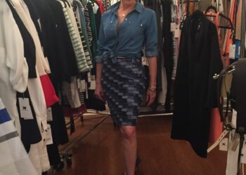 Andrea Greenspan standing between racks of clothing.