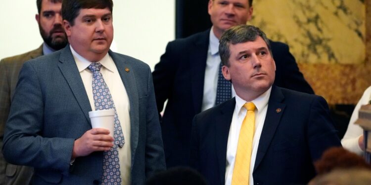 Republican Sens. Jeremy England, R-Vancleave, left, and Daniel Sparks of Belmont, listen as the Senate Clerk tallies the vote on House Bill 401.