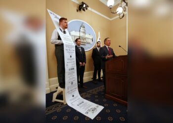 Democratic staff member William Pond, left, wears an enlarged mock-up of a receipt as Assemblyman Phil Ting, D-San Francisco, right, discusses his bill to require businesses to offer electronic receipts, in Sacramento, Calif on Jan. 8. 2019.