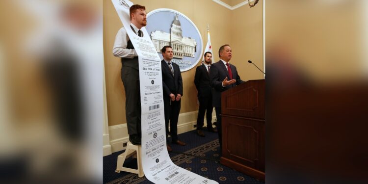 Democratic staff member William Pond, left, wears an enlarged mock-up of a receipt as Assemblyman Phil Ting, D-San Francisco, right, discusses his bill to require businesses to offer electronic receipts, in Sacramento, Calif on Jan. 8. 2019.