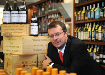 John Kapon leaning over a store counter.