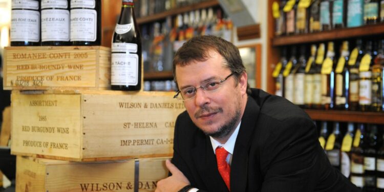 John Kapon leaning over a store counter.