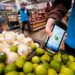 A worker scans onions, limes, and other produce inside a Walmart.