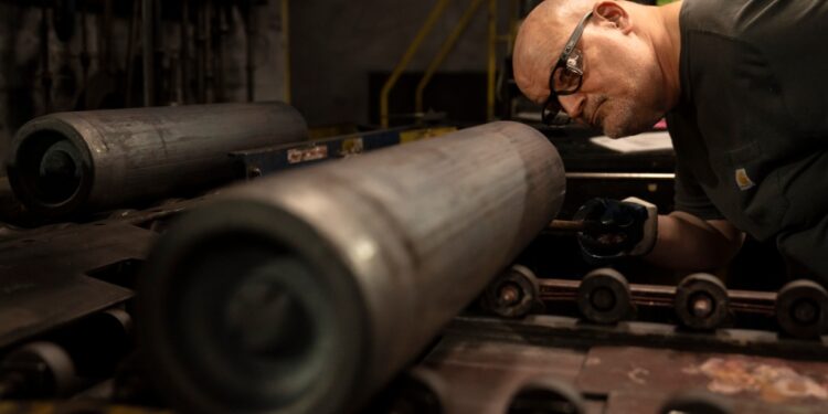 A steel worker inspects a 155 mm M795 artillery projectile during the manufacturing process at the Scranton Army Ammunition Plant in Scranton, Pa.