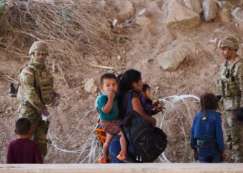 Migrants who crossed the U.S.-Mexico border at the Rio Grande River are denied entry at the base of the Ysleta-Zaragoza bridge