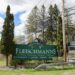 A Fleischmanns sign nestled between trees.