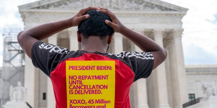 Protesters holding signs advocating for the cancellation of student debt stand in front of the United States Supreme Court