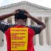 Protesters holding signs advocating for the cancellation of student debt stand in front of the United States Supreme Court