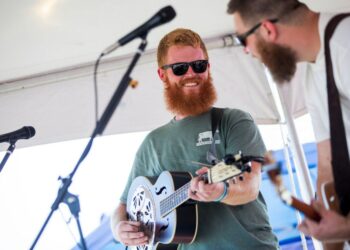 Oliver Anthony smiles while performing on stage
