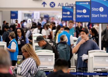 Travelers wait in line at Los Angeles International airport in June.