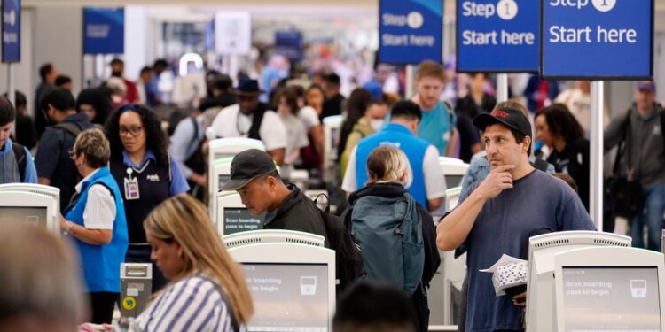 Travelers wait in line at Los Angeles International airport in June.