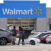A man pushing a shopping cart in front of a Walmart store.