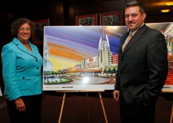 Assembly women Audry Pheffer & State Senetor Joseph P Addabbo stand in front of an isle with a painting of a casino, at a meeting held at Aqueduct racetrack.