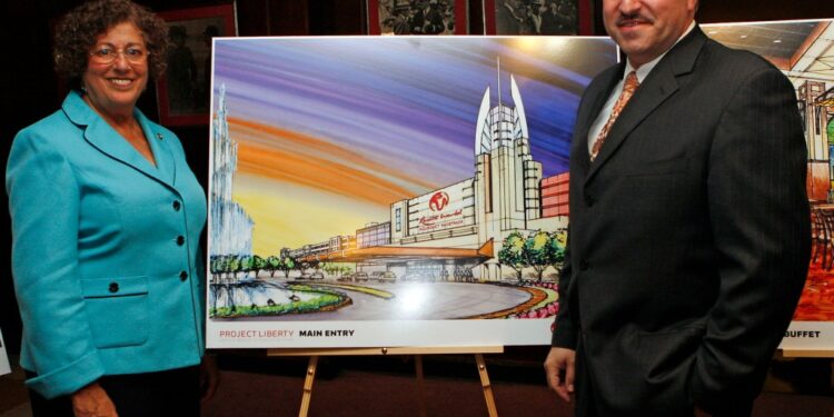 Assembly women Audry Pheffer & State Senetor Joseph P Addabbo stand in front of an isle with a painting of a casino, at a meeting held at Aqueduct racetrack.