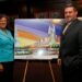 Assembly women Audry Pheffer & State Senetor Joseph P Addabbo stand in front of an isle with a painting of a casino, at a meeting held at Aqueduct racetrack.