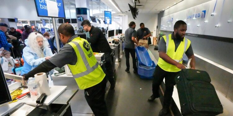 A United worker handles baggage.