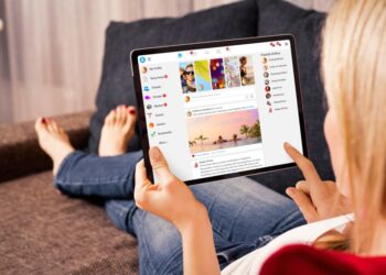 A photo of a young woman looking at her laptop computer.