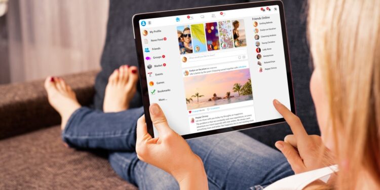 A photo of a young woman looking at her laptop computer.