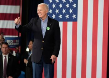 President Joe Biden in a suit, waving to supporters at a campaign event in Atlanta on March 9, 2024