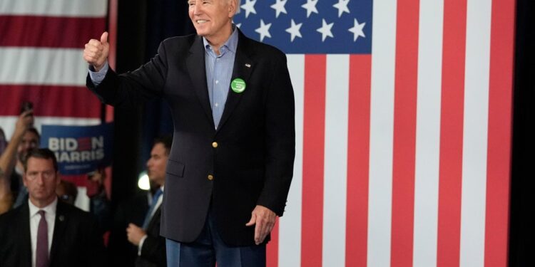 President Joe Biden in a suit, waving to supporters at a campaign event in Atlanta on March 9, 2024