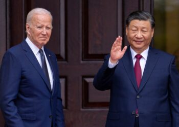 President Joe Biden and China's President Xi Jinping waving in suits during their meeting in Woodside, Calif on Nov, 15, 2023
