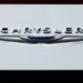 Chrysler logo on display at an auto show with a caption about recalling over 211,000 SUVs and pickup trucks due to a software malfunction
