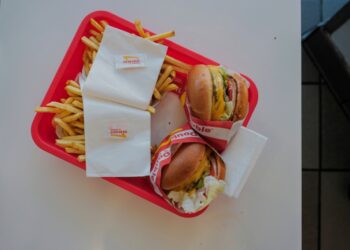 An In-N-Out burger, with a juicy beef patty, melted cheese, fresh lettuce, and tomato all stacked between two soft buns.